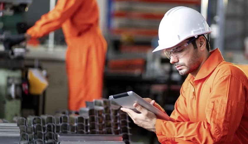 Factory worker using a tablet on the shop floor as part of Dormer Pramet’s digital manufacturing system in Šumperk, Czech Republic, enabled by SAP FRONTO and Axians.