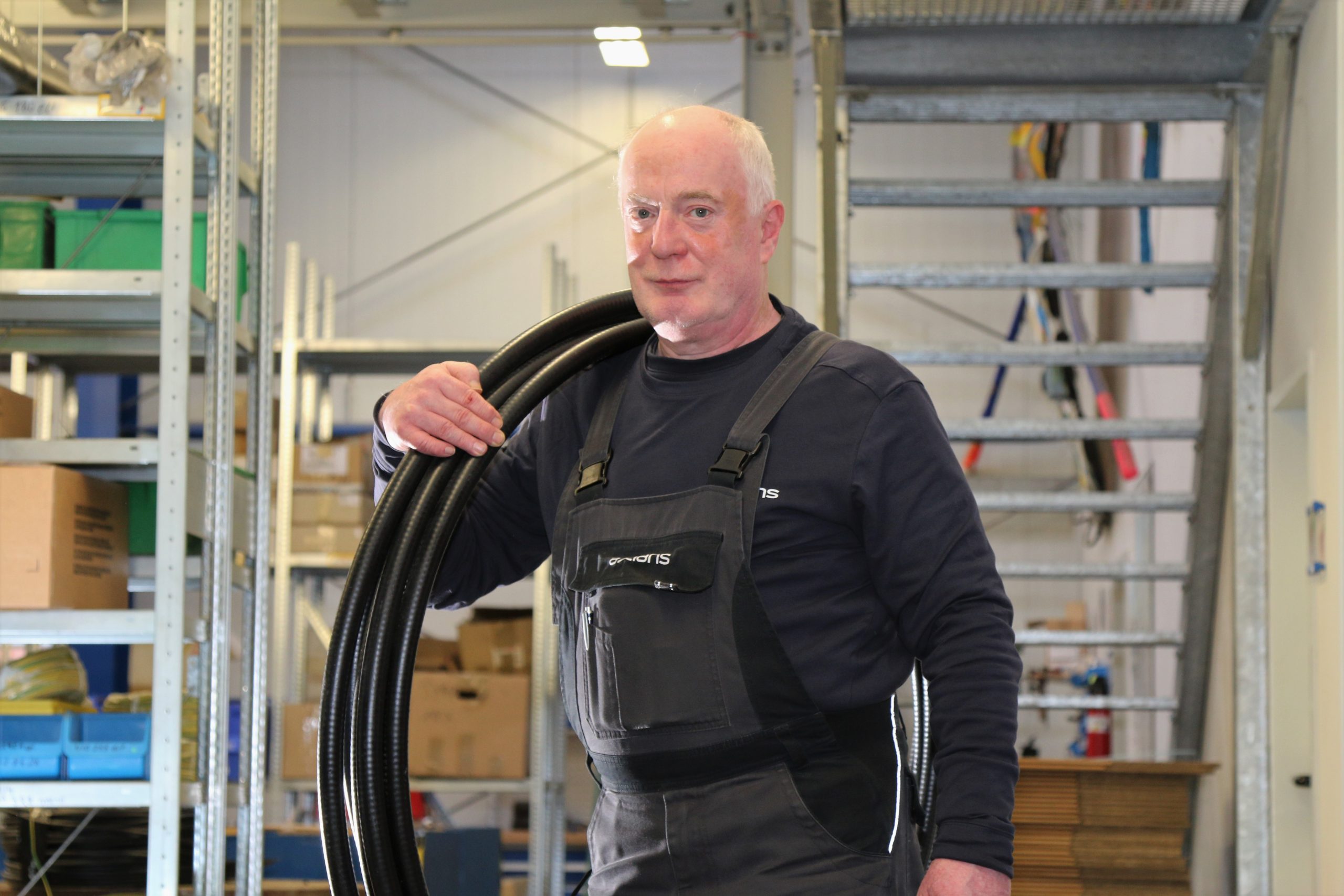 Logistikmitarbeiter des eigenen Logistikcenter trägt Kabel für Antenne
