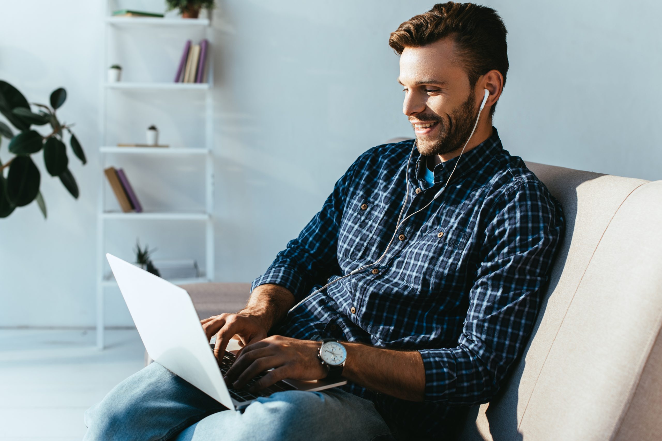 smiling man with earphones taking part in webinar at home